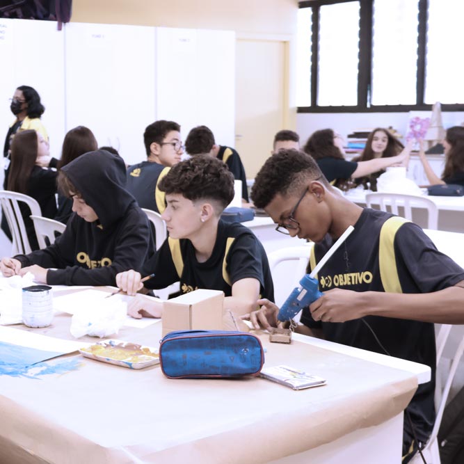 Estudantes pintando em folha de papel